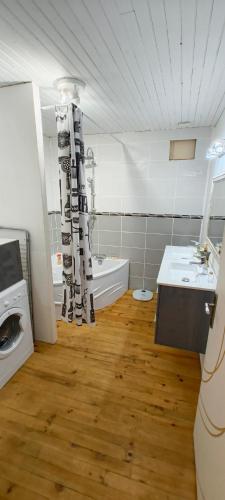 La salle de bains est pourvue d'une baignoire, d'un lavabo et d'un lave-linge. dans l'établissement Appartement Entier, à La Tour-sur-Orb