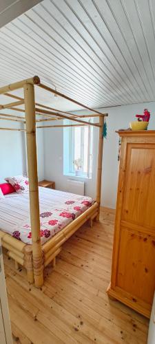 une chambre avec un lit en bois dans une pièce dans l'établissement Appartement Entier, à La Tour-sur-Orb