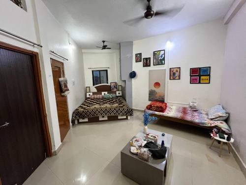 Un dormitorio con dos camas y una mesa dentro. en Ghar Jaisa Stay, en Ujjain