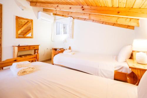 two beds in a room with wooden ceilings at Thetis in Alikanas