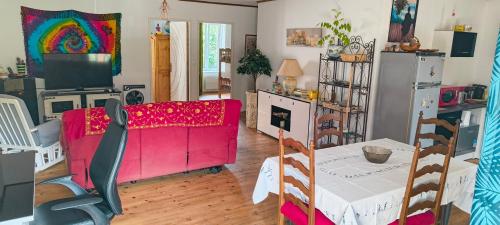 un salon avec un canapé rouge et une table dans l'établissement Appartement Entier, à La Tour-sur-Orb