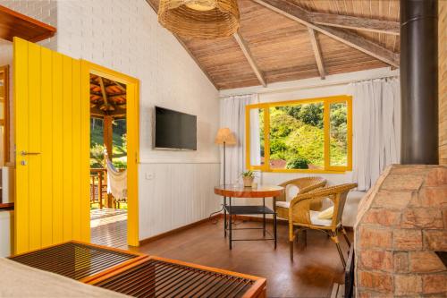 a living room with a yellow door and a table at Parador Lumiar Boutique Hotel & Spa in Lumiar