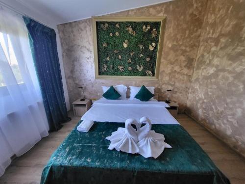 a bedroom with two beds and a painting on the wall at Casa Ratiu 3 Stele Airport Bucharest Therme Bucharest in Baloteşti