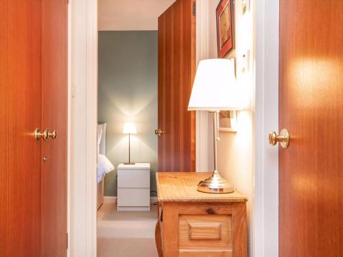 a hallway with a lamp on a wooden table at Strathy in Dornoch