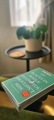 a book sitting on a table next to a plant at Saint Margaret's Guest House in Poole