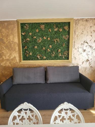 a couch in a room with a painting on the wall at Casa Ratiu 3 Stele Airport Bucharest Therme Bucharest in Baloteşti