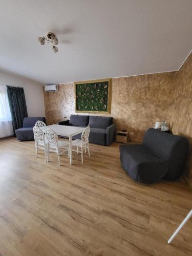 a living room with a couch and a table and chairs at Casa Ratiu 3 Stele Airport Bucharest Therme Bucharest in Baloteşti