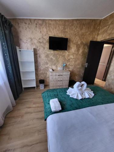 a bedroom with a bed with a towel on it at Casa Ratiu 3 Stele Airport Bucharest Therme Bucharest in Baloteşti