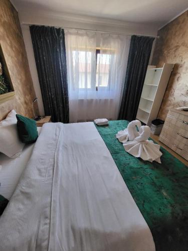 a bedroom with a large bed with a flower on it at Casa Ratiu 3 Stele Airport Bucharest Therme Bucharest in Baloteşti