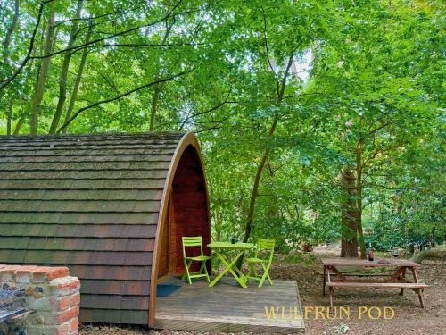 a shed with two chairs and a picnic table at West Stow Pods in Bury St Edmunds in West Stow