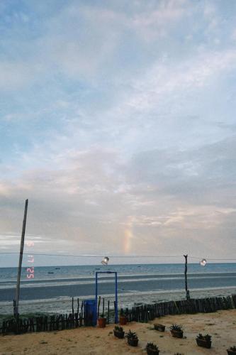 a rainbow in the sky over the beach at Pousada Quinta das Flores in Icapuí