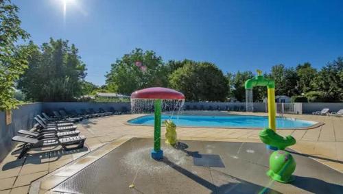 a large swimming pool with a water fountain at Mobil-home xl 4 personnes avec télé in Boofzheim