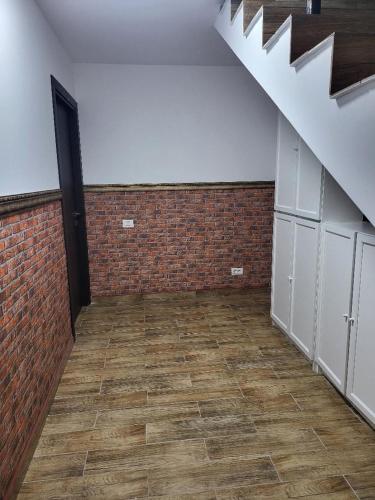 an empty room with a brick wall and a staircase at Casa Ratiu 3 Stele Airport Bucharest Therme Bucharest in Baloteşti