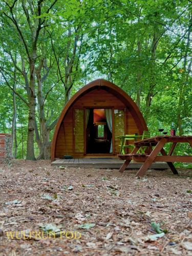 a small tent in the woods with a picnic table at West Stow Pods in Bury St Edmunds in West Stow