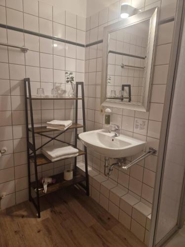 a white bathroom with a sink and a mirror at Hildebrandts Landhotel in Klettbach