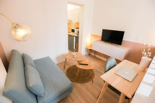 a living room with a blue couch and a table at Stadium Pink Loft 5min Rer near Paris in Aubervilliers
