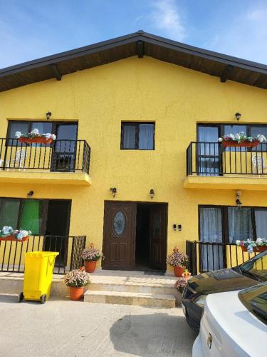 a yellow house with two balconies and a door at Casa Ratiu 3 Stele Airport Bucharest Therme Bucharest in Baloteşti