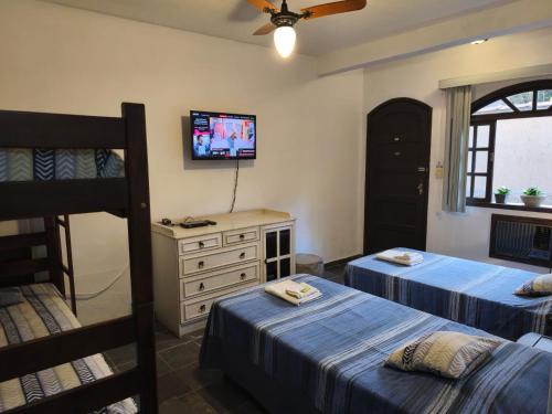 a bedroom with two beds and a bunk bed at Pousada Nascente do Pirahy in Piraí