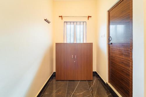 a wooden door in a room with a hallway at Neithal Farm Resort with Swimming Pool by Roscotel in Puducherry