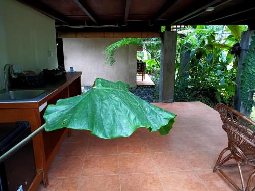 a large green umbrella sitting on a patio at Ubud Jungle Stay by WAHM Hotel Management in Ubud