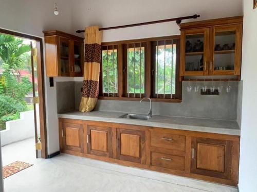 a kitchen with wooden cabinets and a sink at Sunil VIlla in Talpe