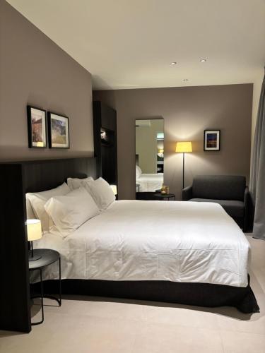 a bedroom with a large white bed and a mirror at Hotel Stelvio Tirano in Tirano