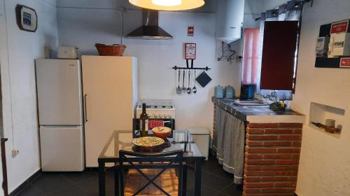 a kitchen with two refrigerators and a table with food on it at Casa da Comadre - Casas de Taipa in São Pedro do Corval