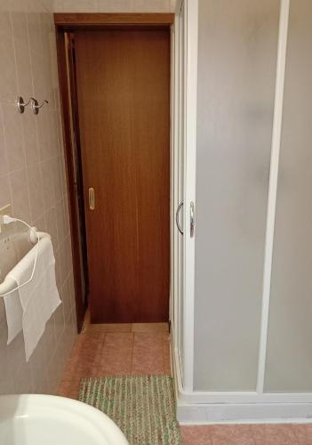 a bathroom with a toilet and a wooden door at Casa Francesco in Peaio