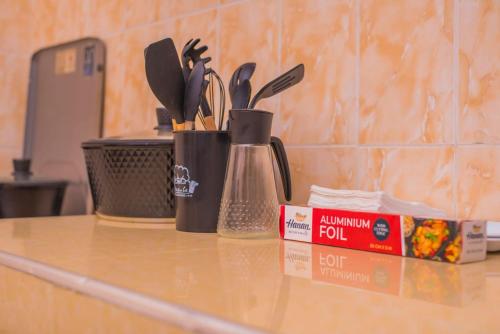 a counter with three utensils and a container on it at Bay Loft Apartment 1 BR Netflix n Internet in Homa Bay