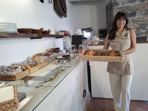 a woman standing in a bakery with a tray of bread at Diana'S in Fiumefreddo di Sicilia