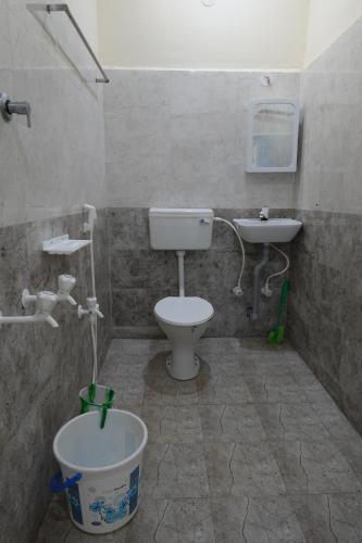 a bathroom with a toilet and a sink at Sivan Paadham Nilayam Guest House in Tiruvannāmalai