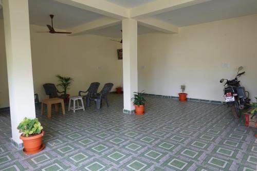 a room with chairs and plants on the floor at Sivan Paadham Nilayam Guest House in Tiruvannāmalai