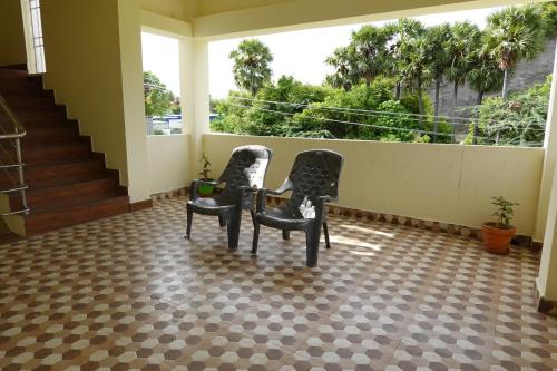 three chairs sitting in a room with a balcony at Sivan Paadham Nilayam Guest House in Tiruvannāmalai