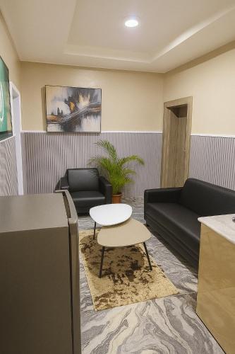 a waiting room with a couch and a table at 154 Apartments and Hotel in Abuja