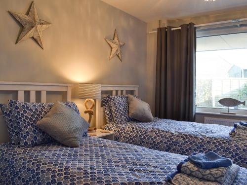 two beds in a bedroom with stars on the wall at Driftwood in Godshill