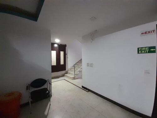 an empty room with a white wall and a staircase at Hotel Mandakini in New Delhi