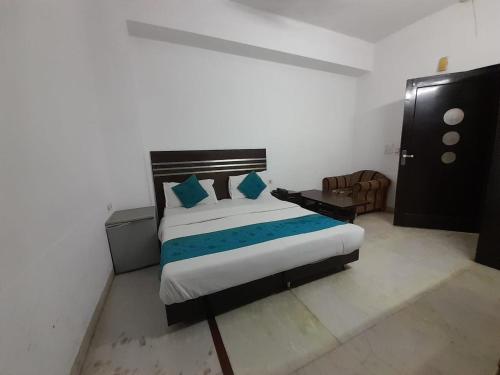 a bedroom with a large bed with blue pillows at Hotel Mandakini in New Delhi
