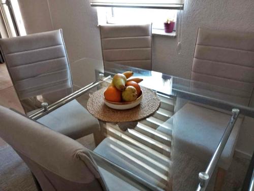a glass table with a bowl of fruit on it at Farah Apartment in Mostar