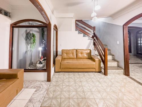 a living room with a couch and a staircase at Casa Araçás in Vila Velha