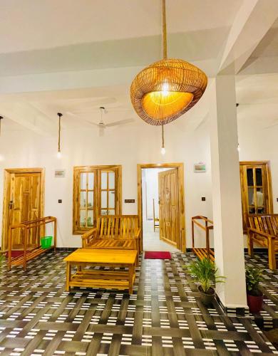 a room with wooden benches and a chandelier at Eastern Bay in Arugam Bay