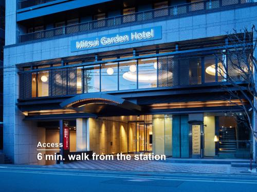 a building with a sign that reads access min walk from the station at Mitsui Garden Hotel Kyoto Shijo in Kyoto