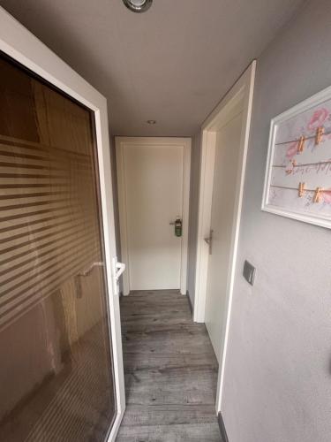 a hallway with a door leading to a room at gemütliches Zimmer mit eigenem Bad und separatem Eingangstor in Erxleben