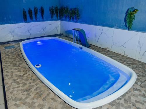 a blue tub in a bathroom with a tile floor at Casa Araçás in Vila Velha