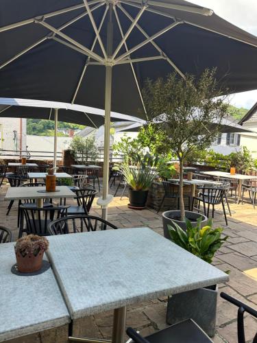 a patio with tables and chairs with an umbrella at Landgasthof Zur Sonne in Enkirch