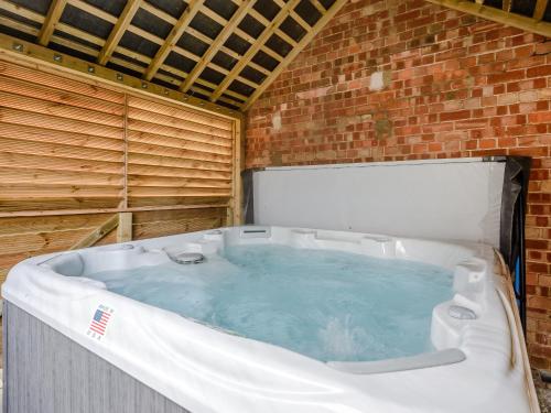 eine große Badewanne in einer Ziegelwand in der Unterkunft Kingfisher Cottage in Wainfleet All Saints
