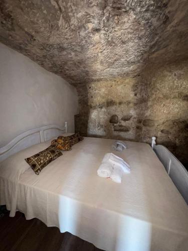 a bedroom with a bed with towels on it at La grotta Mutycense in Modica
