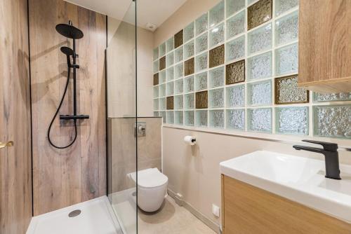 a bathroom with a shower and a toilet and a sink at Moulin de la Touche - Domaine Piscine in Plouguenast Langast