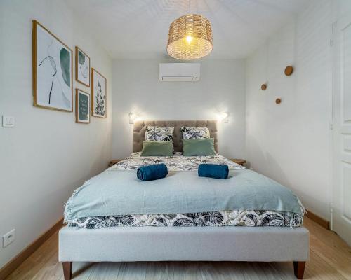 a bedroom with a large bed with blue pillows at The Kings Haven with Garden in Bois-le-Roi