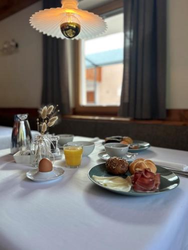a table with a plate of breakfast foods on it at Pension Grohmann in Santa Cristina in Val Gardena