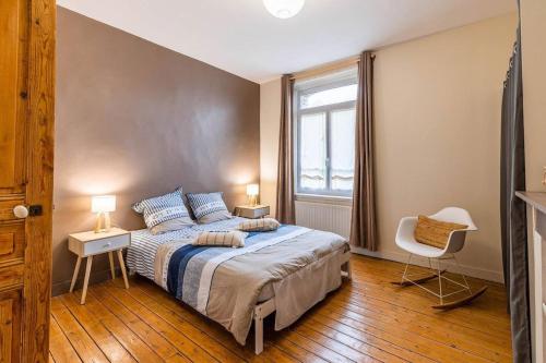 una camera da letto con un letto, una finestra e una sedia di Villa Au Beau Site Jardin, Cheminée & Mer proche a Merlimont
